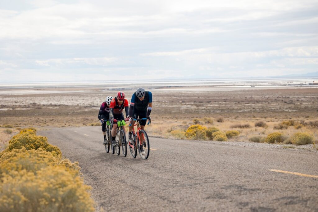 Three riders grind out a climb in a headwind on the Salty Lizard 100 course