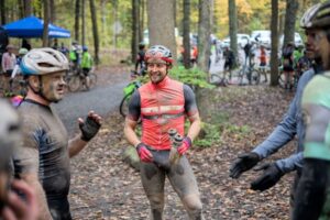 Men dressed in cycling kits with mud splattered all over them discuss their experiences after the unPAved ride.