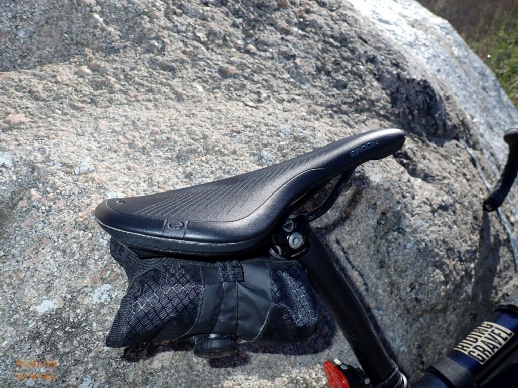 A close up of the Ergon SR Allroad Core Comp saddle against a large boulder