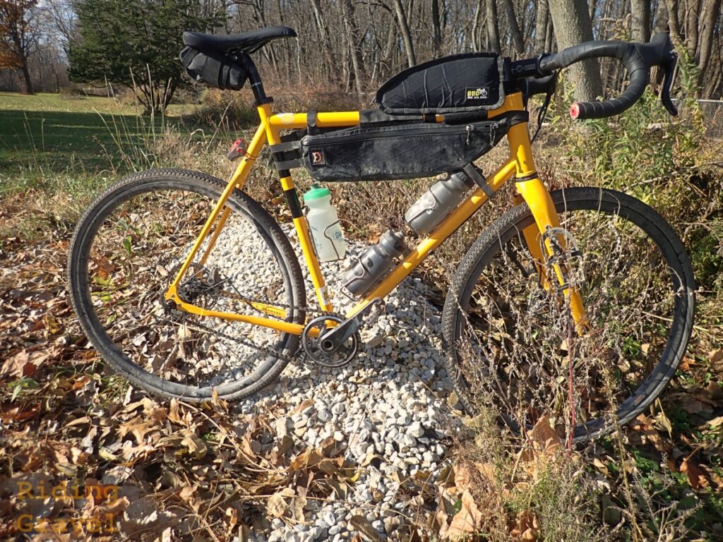 A yellow bike with bags on a rock pile with tires set up with the FiberLink sealant