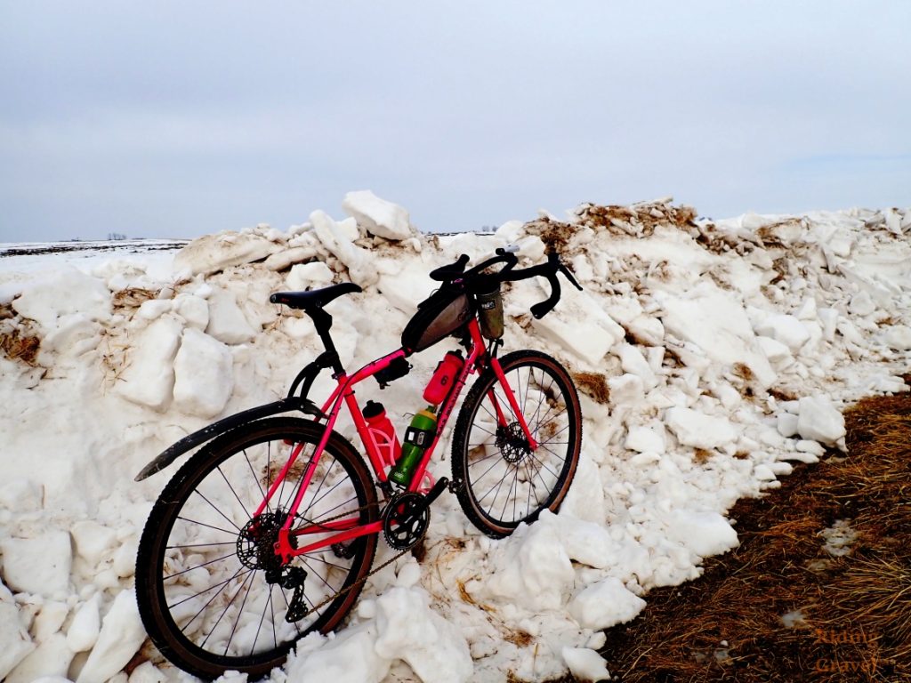 Guitar Ted's Black Mountain Cycles MCD bike outfitted with the Redshift Sports ShockStop Pro Seat Post as the bike is sitting in a snow bank in a rural scene.