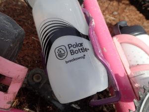 Close up of a Polar Bottle Breakaway series bottle in a water bottle cage on a bicycle.