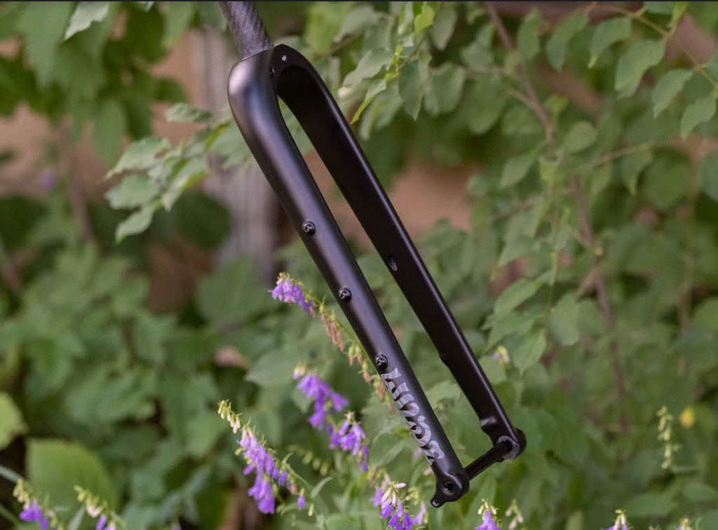 Wilde Carbon fiber bicycle fork in an outdoor, greenery setting.