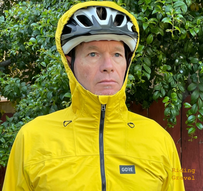Lupra Jacket with hood drawn over a cycling helmet on a model. 