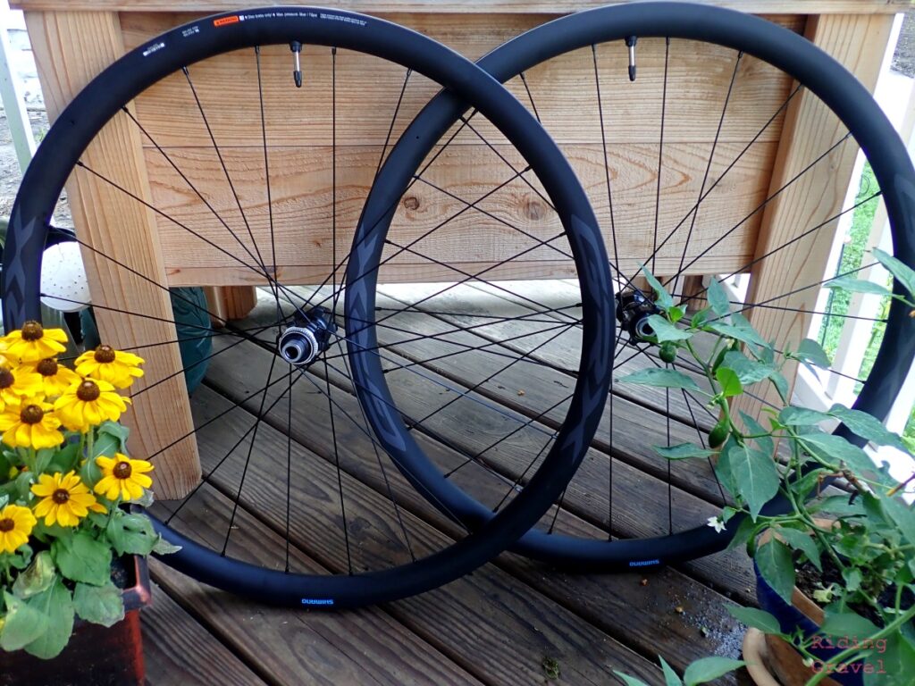 Shot of a pair of GRX Carbon wheels from Shimano with flowers and pepper plants