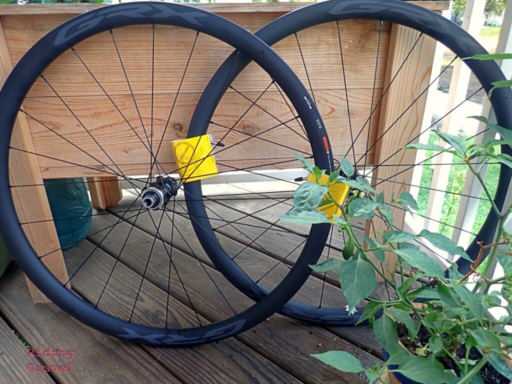 A set of Shimano GRX Carbon wheels on a porch next to a pepper plant