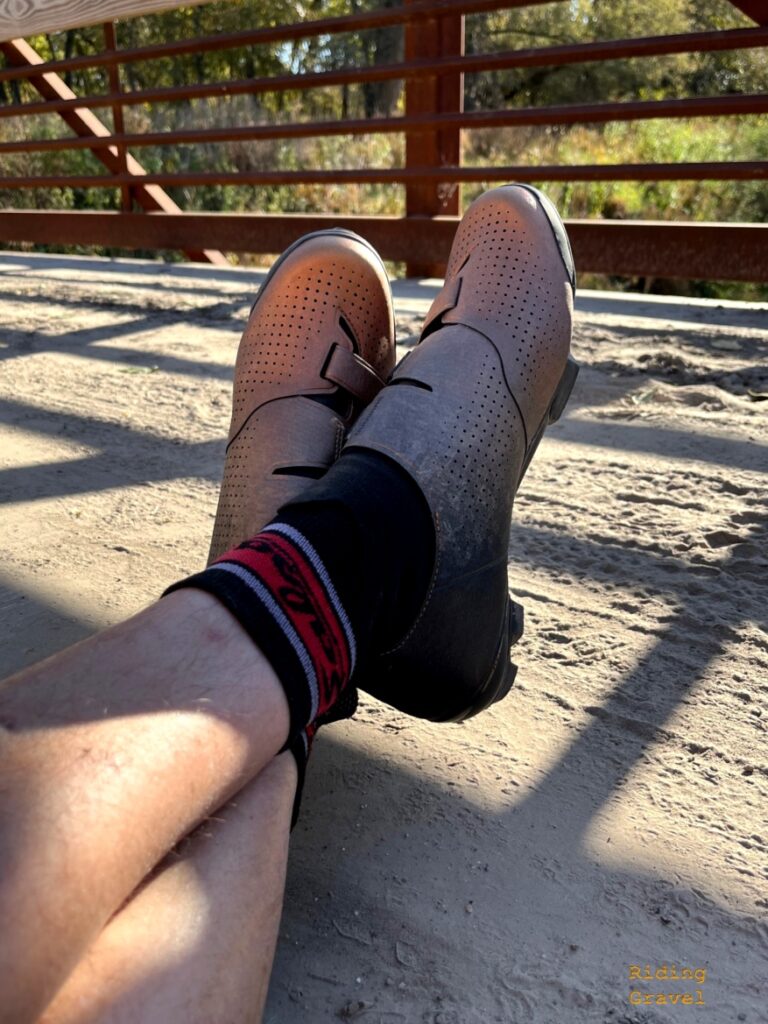 Close up of MG wearing the Shimano RX8R shoes with legs crossed on a bridge. 