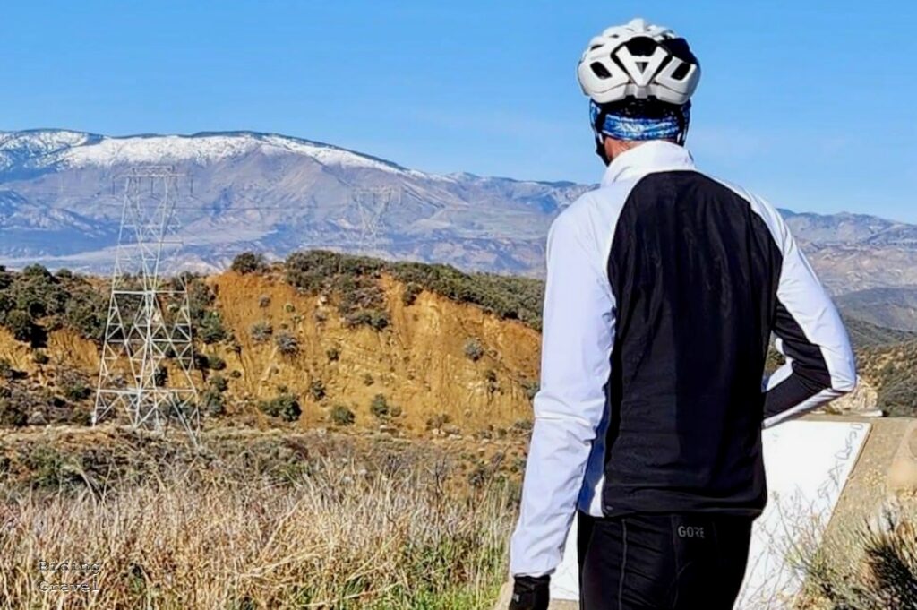 Grannygear looking out over some snow capped mountains while wearing the Bontrager gear.