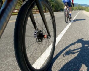 Close up of the front wheel on the Alchemy bike on a paved highway. 