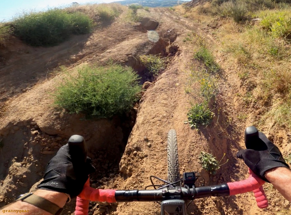 Image from a cyclists viewpoint of a rutted out dirt path